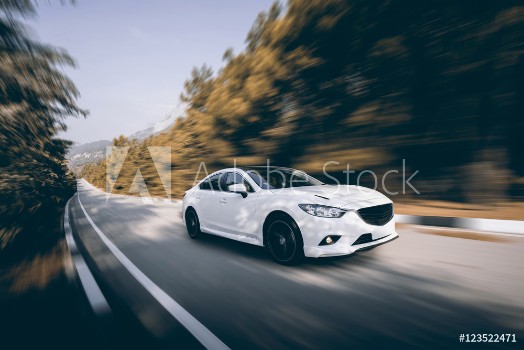 Picture of White car speed driving on asphalt road at daytime